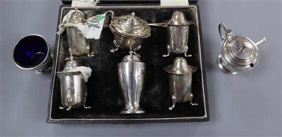 A 1930s Art Deco silver three piece condiment set and a cased George V silver five piece condiment set.